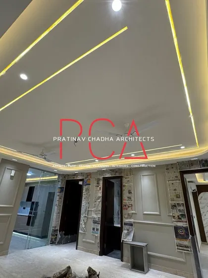 The ceiling design in the Vasant Kunj residence, with curved profiles and integrated linear lighting creating a dynamic and modern effect.