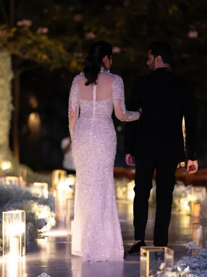 Creating a romantic and cozy atmosphere with soft, delicate lighting. The couple is surrounded by dozens of candles, casting a warm glow that is perfect for intimate reception photos.