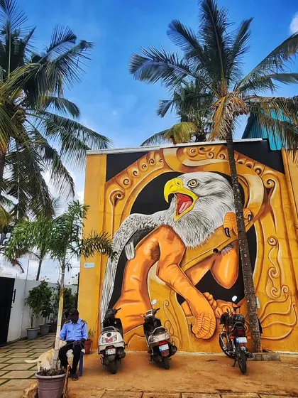 Another wide shot of the eagle mural, framed by palm trees, which adds to its majestic presence.