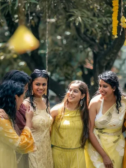 The bride tribe sharing a happy moment. The yellow color theme for this Haldi ceremony extended to the guests' attire, creating a visually cohesive and cheerful atmosphere.