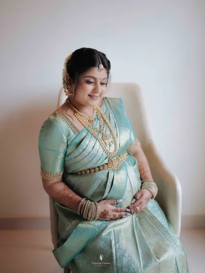 An elegant solo maternity portrait showcasing the mother's radiant glow. The simplicity of the setting puts all the focus on her, her beautiful silk saree, and the precious life she is carrying.
