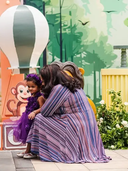 A sweet moment between mother and daughter in front of the jungle backdrop. The life-sized 'TWO' blocks are a great prop for birthday photos.