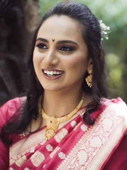 A candid shot of the smiling bride. Her natural, glowing makeup and soft hairstyle look just as stunning in natural light as they do indoors.