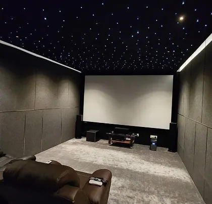The view from the back of the room, showing the large, blank screen ready for projection, and the simple, effective acoustic treatment.