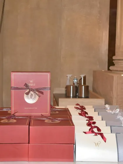 A close up shot of our custom gift boxes, stacked and ready for guests. Every element, from the box color to the ribbon and the themed seal, was carefully chosen to create a luxurious and on brand unboxing experience for attendees.