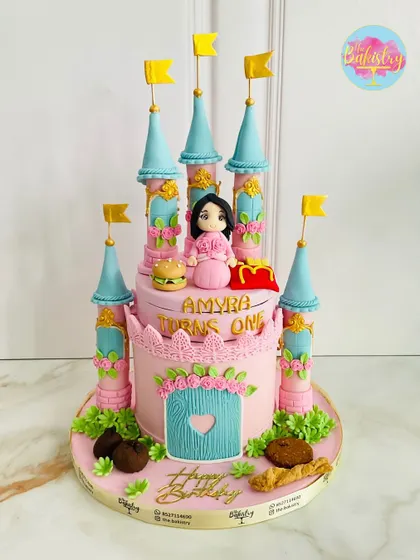 A princess castle cake for Amyra's first birthday, complete with her favorite treats. I added a tiny edible burger and fries for a fun, personalized touch!