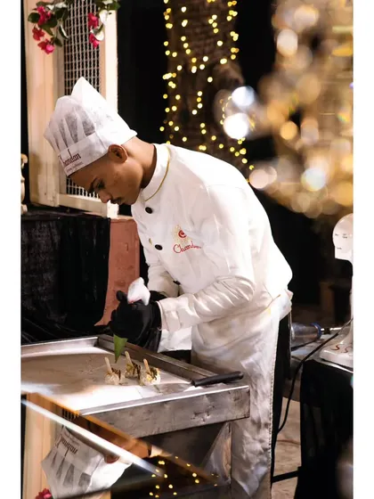A chef meticulously preparing bite-sized appetizers at a live station. The focus and precision ensure that every single piece is perfect.