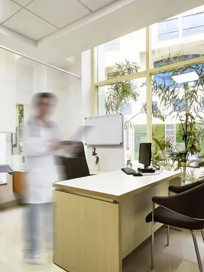 A doctor's consultation room in the new wing of Ramakrishna Care Hospital. Large windows provide natural light and views of the campus greenery, creating a calm and professional environment for patient interactions.