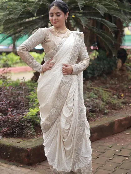 A full-length view of the stunning white Nauvari, showcasing its unique drape and the elegant full-sleeve blouse.
