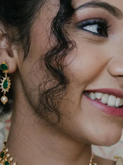 A candid side profile, capturing the bride's natural radiance. The makeup is designed to look good from every angle, all night long.