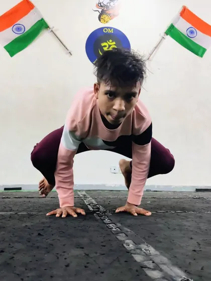 A young warrior in a deep squat pose, building lower body strength and hip mobility. These foundational movements are crucial for athletic performance.
