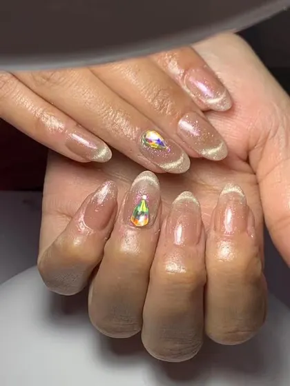 A simple and elegant set with a sheer cat eye base and a single large, teardrop-shaped crystal on each hand.