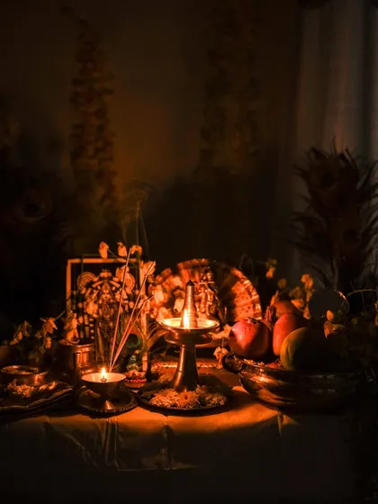 A dark and moody photograph of the Vishu kani, with shadows and light playing together to create a dramatic and intimate atmosphere.