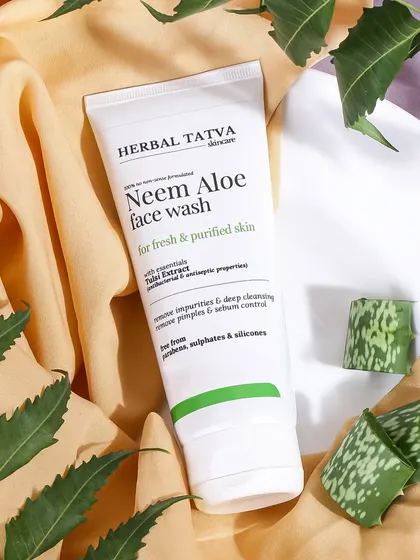A soft and natural setting for a Neem Aloe face wash. The gentle fabric and neem leaves create a calming and purifying visual that speaks to the product's gentle cleansing properties.