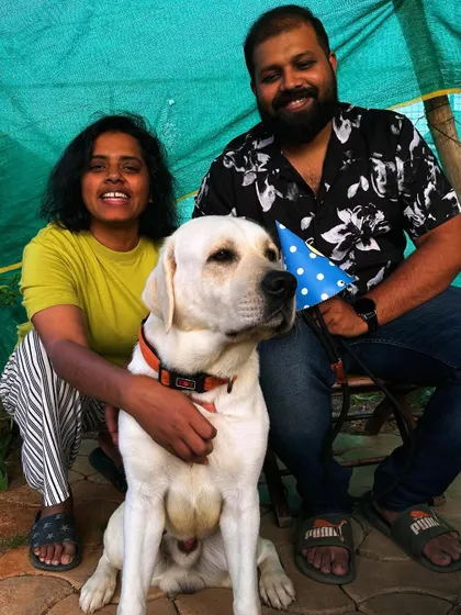 A lovely photo of a couple posing with their white Labrador during his birthday celebration at the ranch.