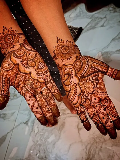 An asymmetrical party mehendi where each hand has a different design. This is a fun way to showcase different styles, from mandalas to flowing Arabic patterns.