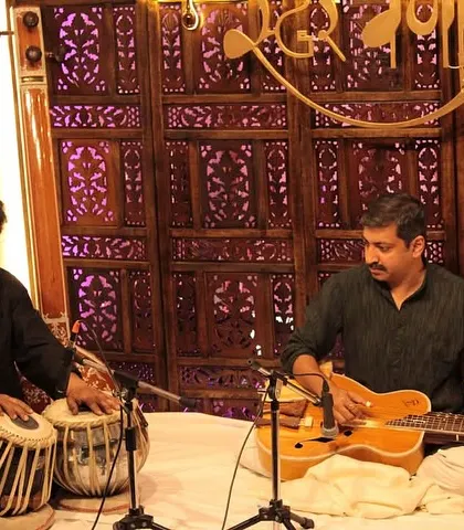 The intricate dialogue between the slide guitar and tabla, showcasing a blend of melody and rhythm in our intimate concert setting.