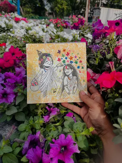 The Radha-Krishna painting surrounded by a bed of real flowers, blending art with nature.