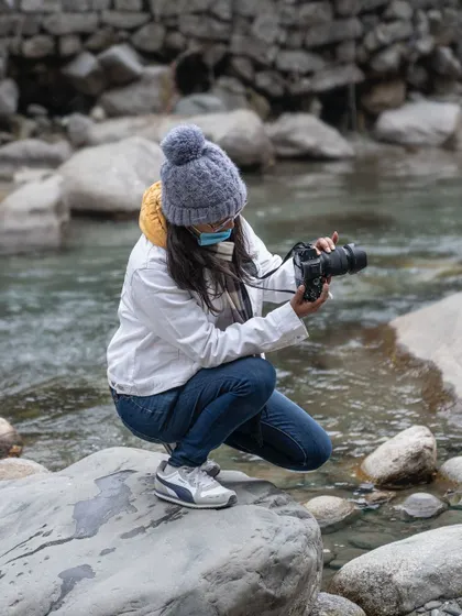 In my element, composing a shot by a river in Manali. I'm most at home when I'm looking at the world through my viewfinder, trying to capture its beauty.