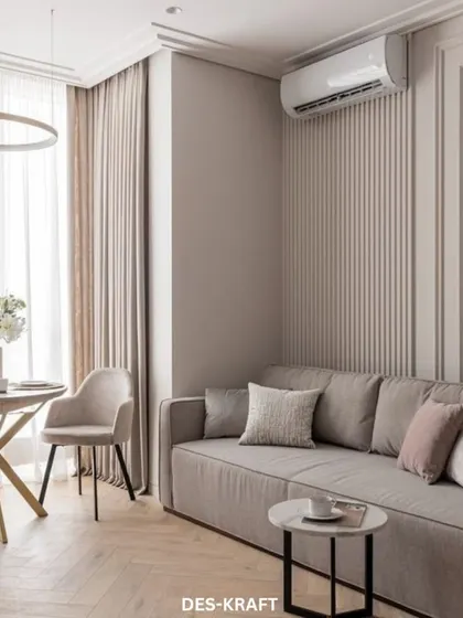 A compact yet elegant living space designed with soft, neutral tones. The fluted wall paneling adds subtle texture, while the plush sofa invites relaxation.