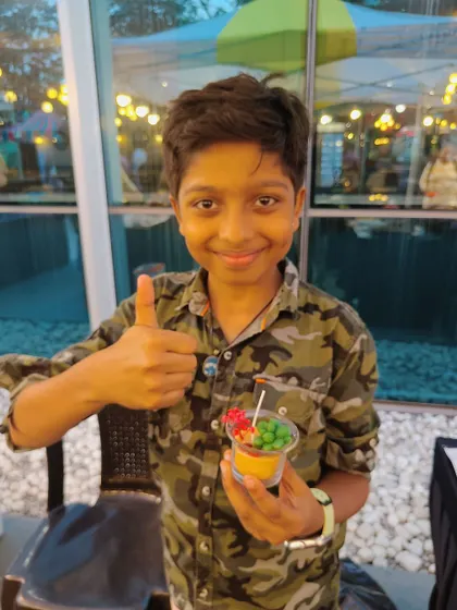 A young boy gives a thumbs-up, happy with the colorful candle he just made at our live booth.