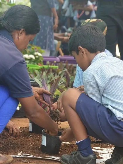Teamwork makes the dream work. A student gets one-on-one guidance from our staff on how to properly repot a plant, a fundamental skill for any plant parent.