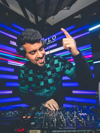 Pointing to the sky, feeling the energy from the crowd. A great shot of me interacting with the audience while mixing tracks on my Pioneer setup.