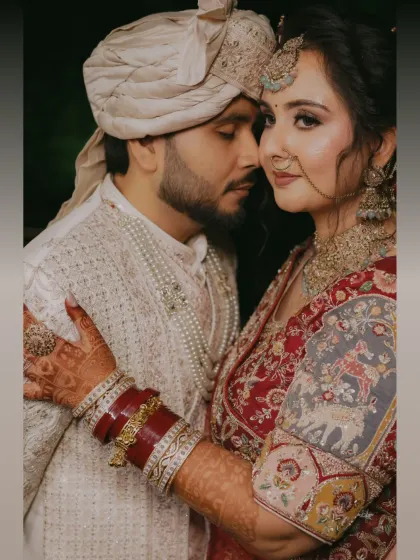An intimate close up of the bride and groom. Her intricate henna, the rich red of her bangles, and their gentle embrace tell a story of love and tradition.