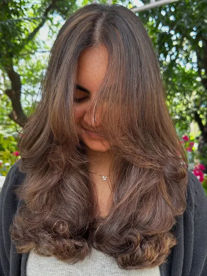 A soft, layered cut that falls beautifully around the face. This style is versatile and can be worn straight or with waves.