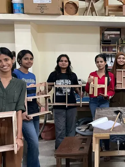 Another group of proud design students with their finished projects, which include a variety of unique and creative shelf designs.