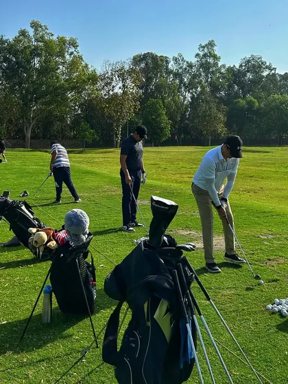 A close-up of golf bags and players on the chipping green, ready for a serious practice session.