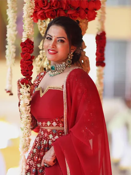 A close-up of the bride-to-be in the stunning red embroidered lehenga, perfect for a wedding ceremony or engagement.