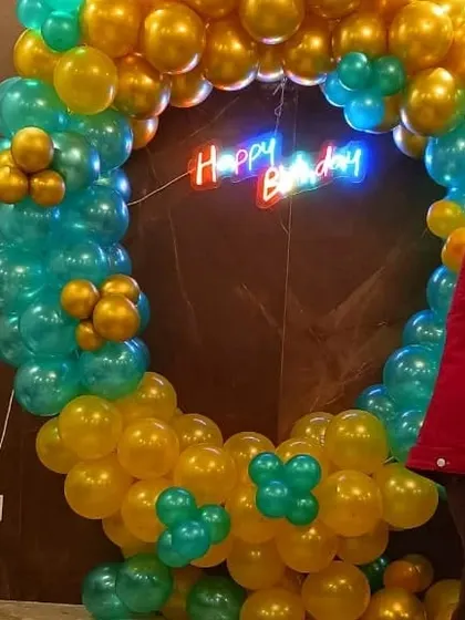 A close-up of our popular ring decoration. This one, in teal and gold, is a great backdrop for photos. We added a 'Happy Birthday' neon sign in the center to complete the look for this office celebration.