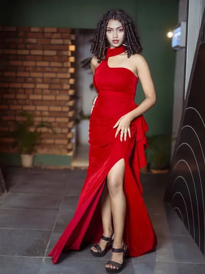 A full-length shot of the model in the red halter gown, showing her powerful pose.
