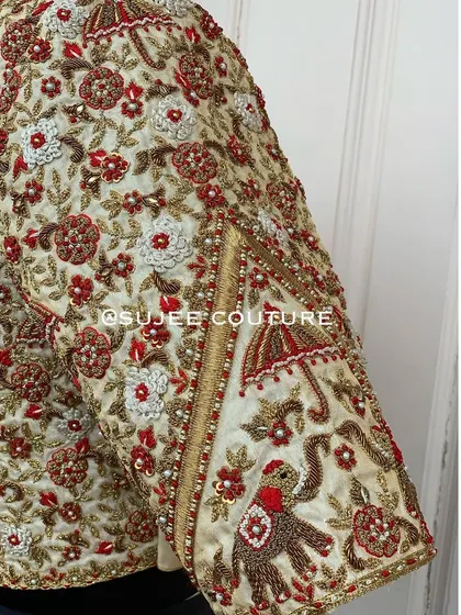 It's all in the details. This close-up shows the traditional 'doli' motif, featuring hand-embroidered elephants and umbrellas, bringing a story to life on the sleeve of a bespoke bridal blouse.