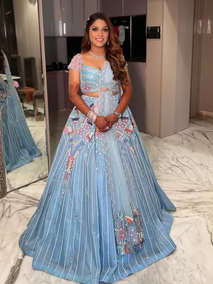 A full view of this bold and beautiful carnival sangeet outfit. The makeup is glamorous and designed to stand out, with defined eyes and a radiant complexion.