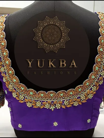 A full back view of a purple blouse with a scalloped U-neck. While the design is primarily floral, you can spot subtle peacock-inspired elements in the embroidery.