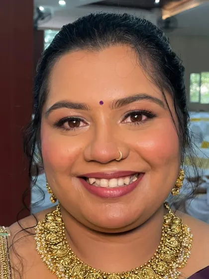 A straight-on shot showcasing the minimal makeup look. The focus is on clean skin, defined brows, and a lip color that enhances her natural tone.