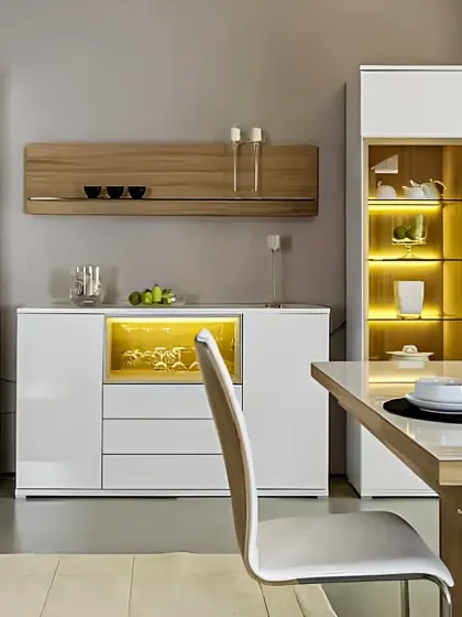 This dining area features sleek, modern crockery units with a high-gloss white finish and natural wood accents. The internal lighting in the glass-fronted cabinets beautifully showcases the dinnerware, adding both storage and display value.