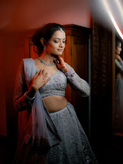 A moody and artistic portrait of the bride looking at her reflection in a mirror before her reception.
