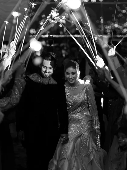 The couple's grand entrance to their reception through a tunnel of sparklers held by their friends and family. This creates a magical, celebratory, and photo-worthy start to the evening.