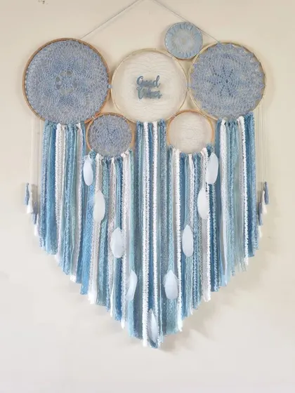 A unique color choice for a living room. This ice blue cluster dreamcatcher is perfect for creating a serene and relaxing backdrop in any space.