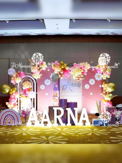 A lovely Boho Rainbow themed stage for an Annaprashan ceremony, combining pastel balloons, rainbow props, and floral details with marquee letters.