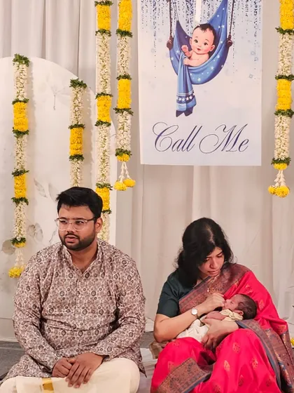 It warms our hearts to see families create beautiful memories against the backdrops we design. Here, the new parents share a quiet moment with their baby during the Noolukettu ceremony we decorated.