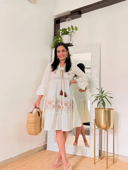 A white dress with delicate embroidery and tassels. This has a lovely boho-chic vibe and is perfect for a vacation.