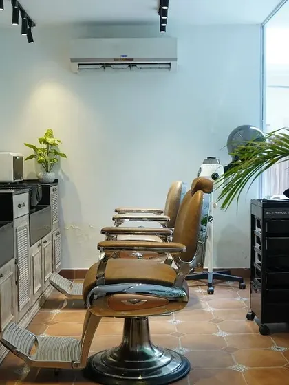 The men's grooming area is designed to be both functional and relaxing, with plenty of natural light and comfortable, professional-grade equipment.