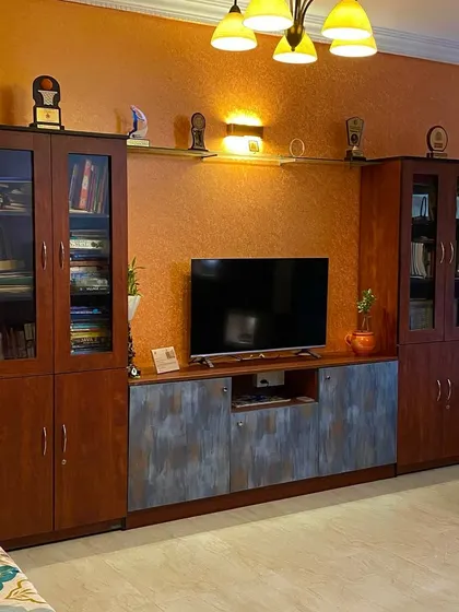 A classic TV unit with ample storage, including glass-fronted cabinets for books and decor. The dual-tone finish adds a touch of modern flair to the traditional design.