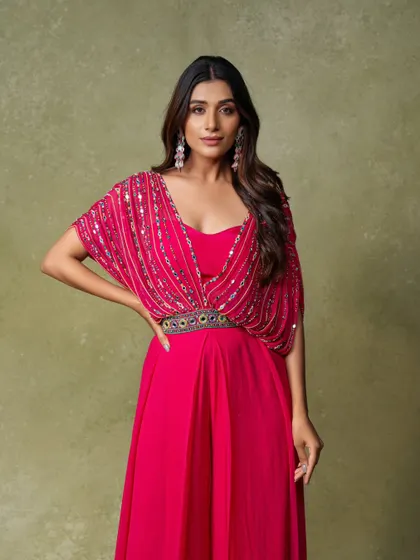 An elegant three-quarter portrait for a festive wear campaign. The lighting beautifully captures the detail on the embellished pink gown.