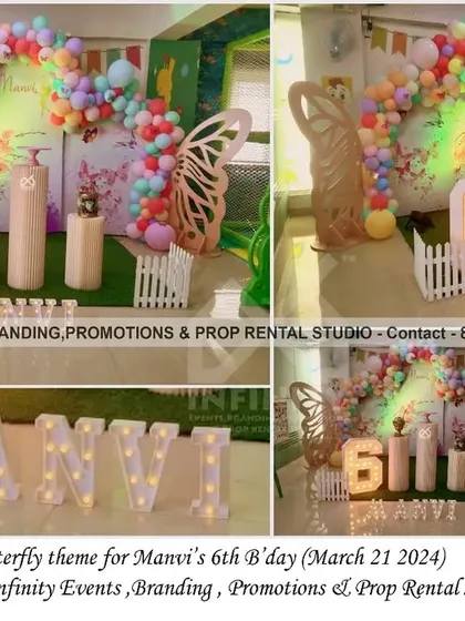 This colorful butterfly theme for a 6th birthday features a pastel balloon garland against a green backdrop. Large butterfly wing props and a light-up number "6" make this a vibrant and fun setup for an older child.