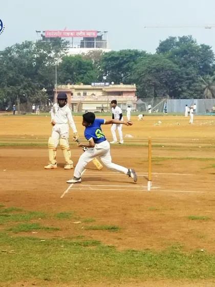 A young cricketer mid-delivery on the pitch, with the coach observing closely. We focus on developing powerful and accurate bowling action through consistent practice and expert feedback.